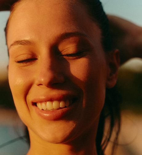 Young woman smiling in warm sunlight