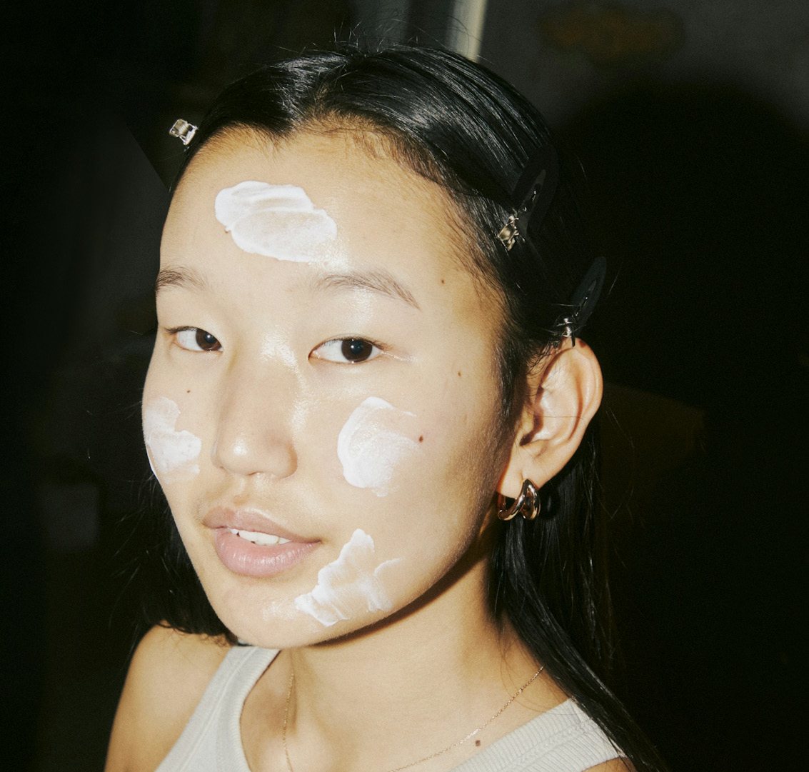 Young woman with sunscreen dabbed on her face